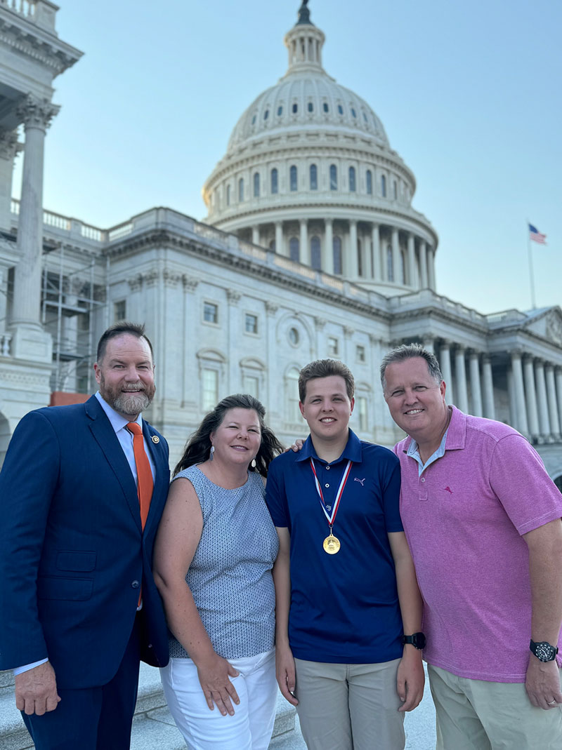 Luke Cooper stands with his parents and U.S. Rep. Aaron Bean after receiving the Congressional Award Gold Medal